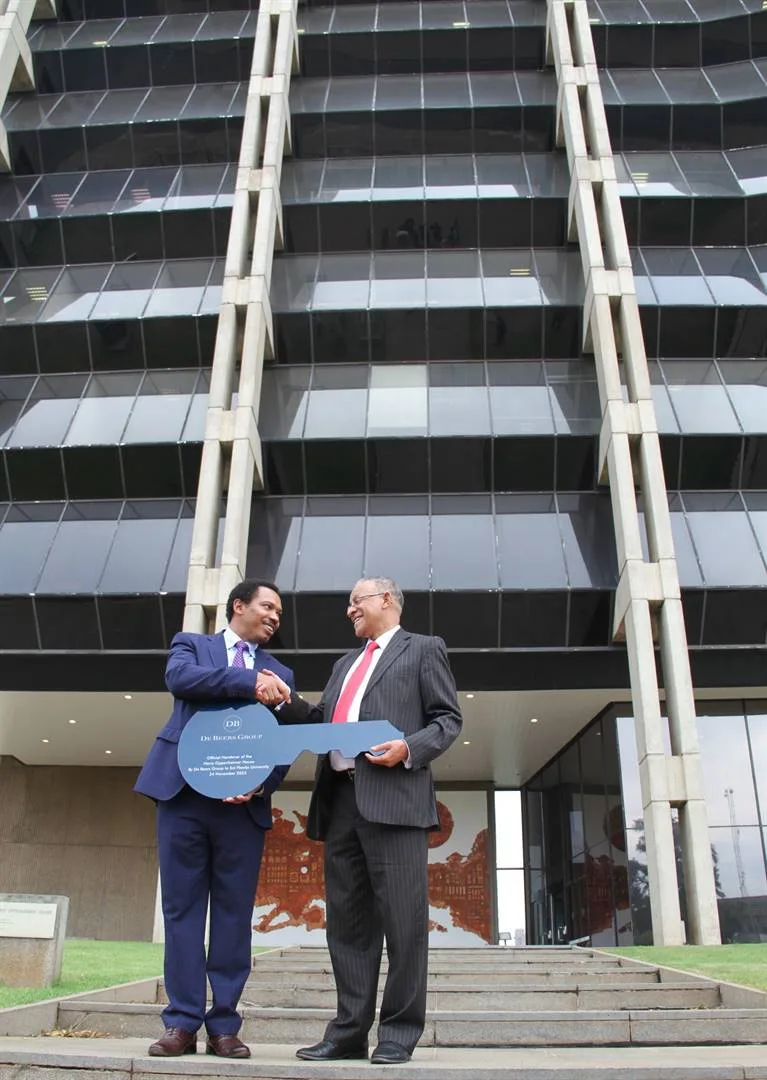 Moses Madondo and Professor Andrew Crouch shake hands outside the Harry Oppenheimer House in Kimberley during the official transfer of the De Beers building to Sol Plaatje University in 2023.