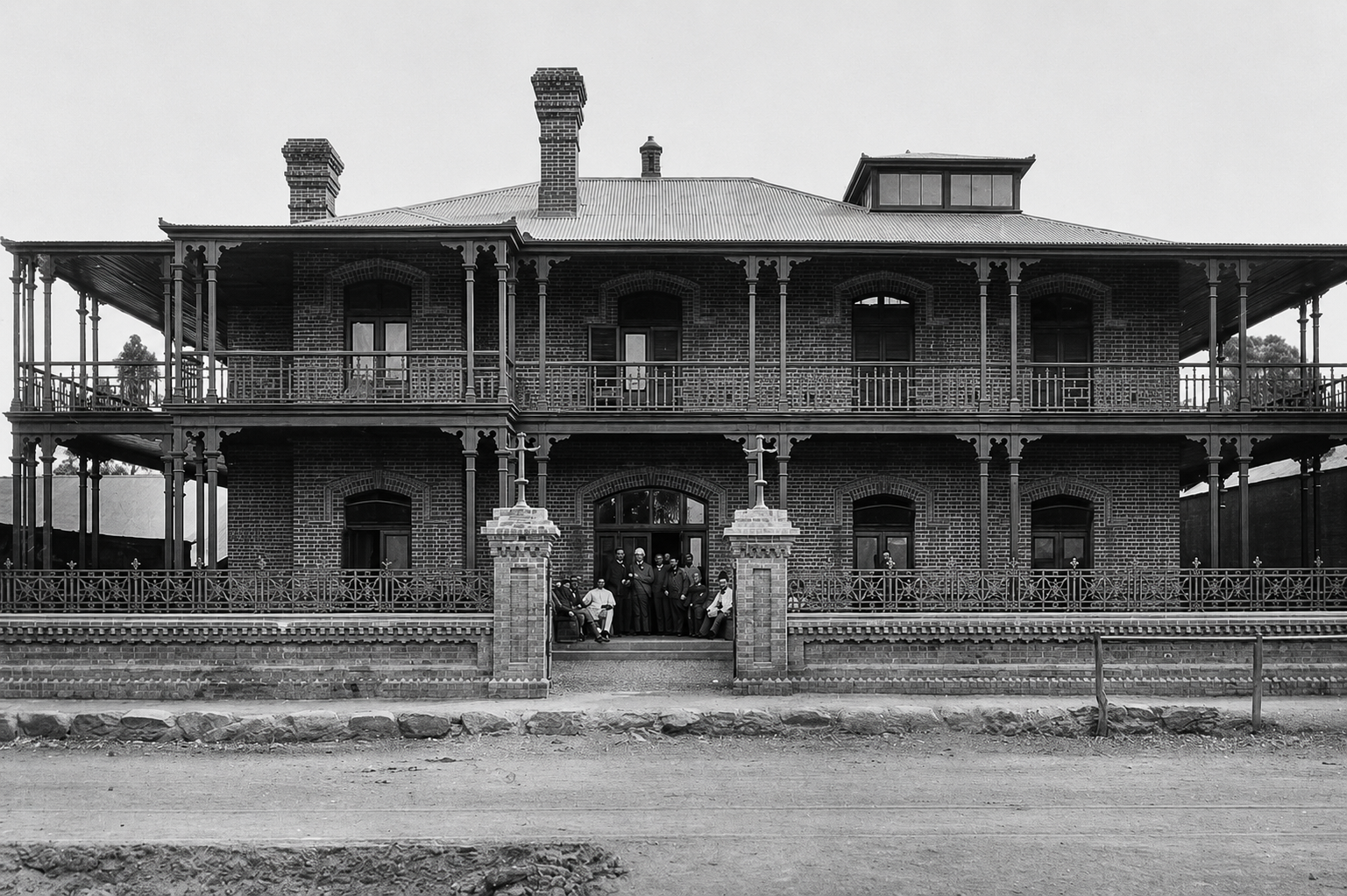 The second Kimberley Club on Du Toitspan Road, showing the two-storey verandahs, raised roof lantern, front chimney, entrance gates and horse-hitching rail.