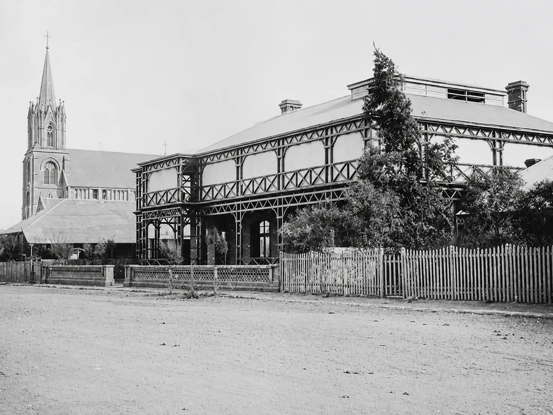 The original Kimberley Club on Du Toitspan Road, Kimberley, 1882–1886, with timber verandahs, raised roof monitor with clerestory windows and horse-hitching rail.