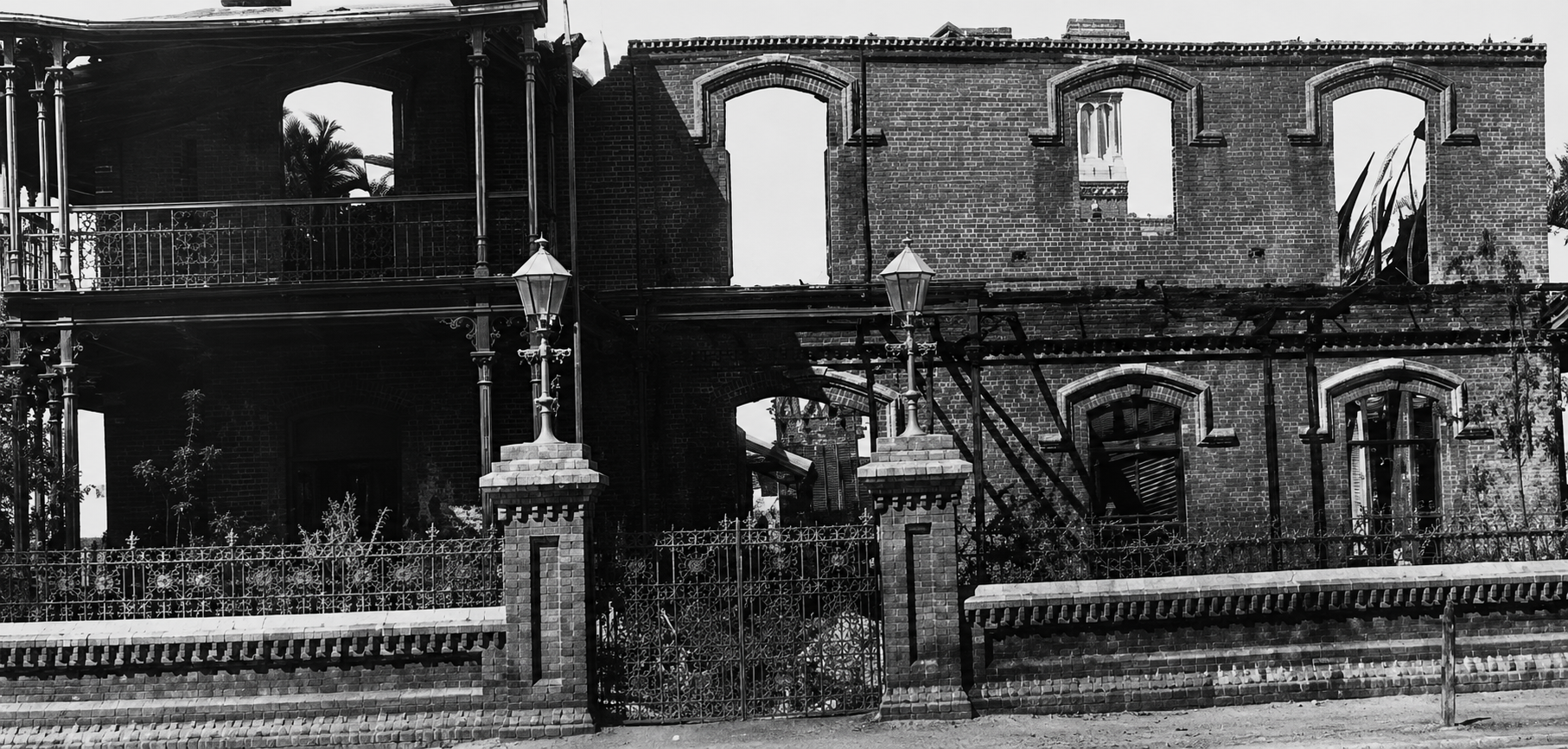 Ruins of the second Kimberley Club after the fire of 11 October 1895, with gutted brick walls and surviving entrance pillars and lanterns.