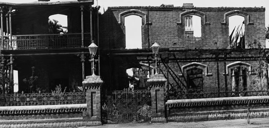Ruins of the second Kimberley Club after the fire of 11 October 1895, with gutted brick walls and surviving entrance pillars and lanterns.