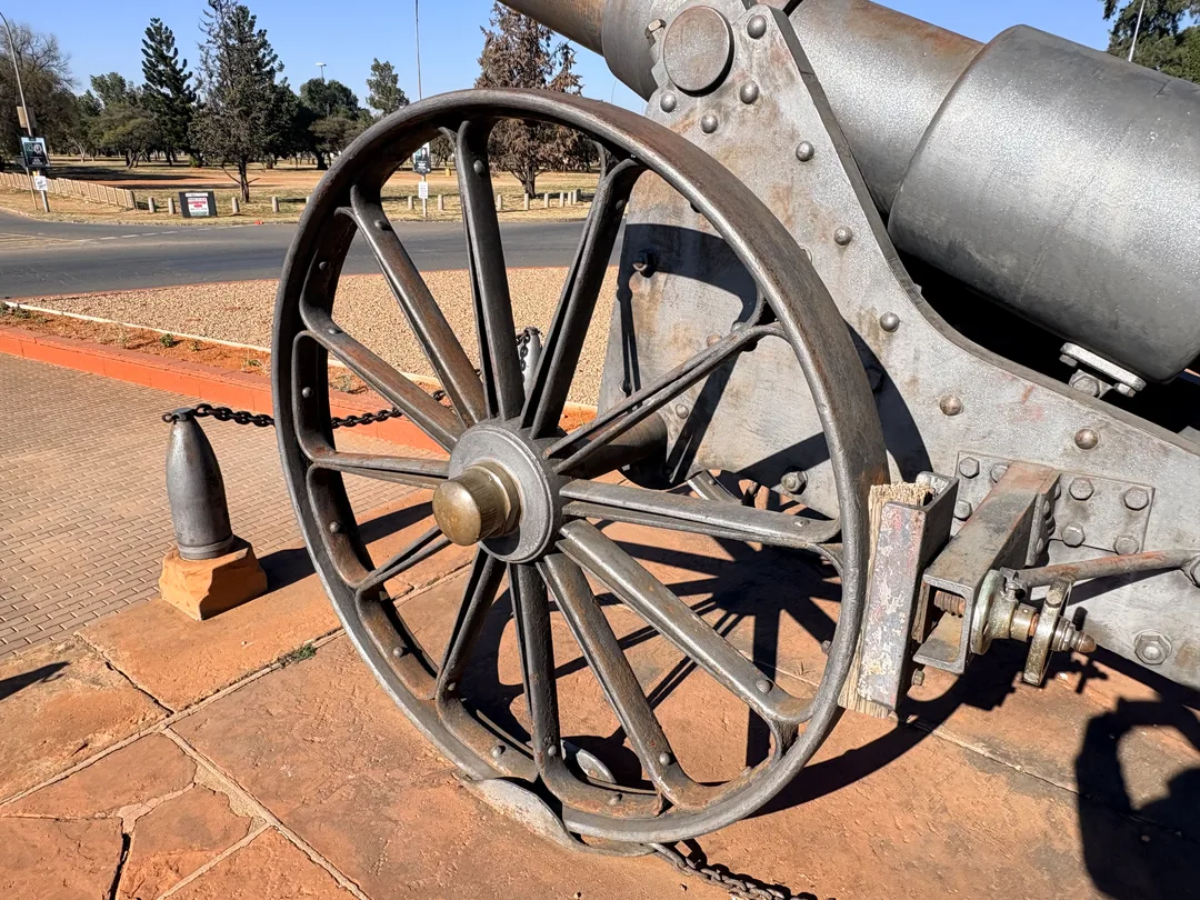 Detailed view of Long Cecil's steel-spoked wheel and gun carriage, showcasing the craftsmanship achieved by the De Beers engineers during the Siege of Kimberley.