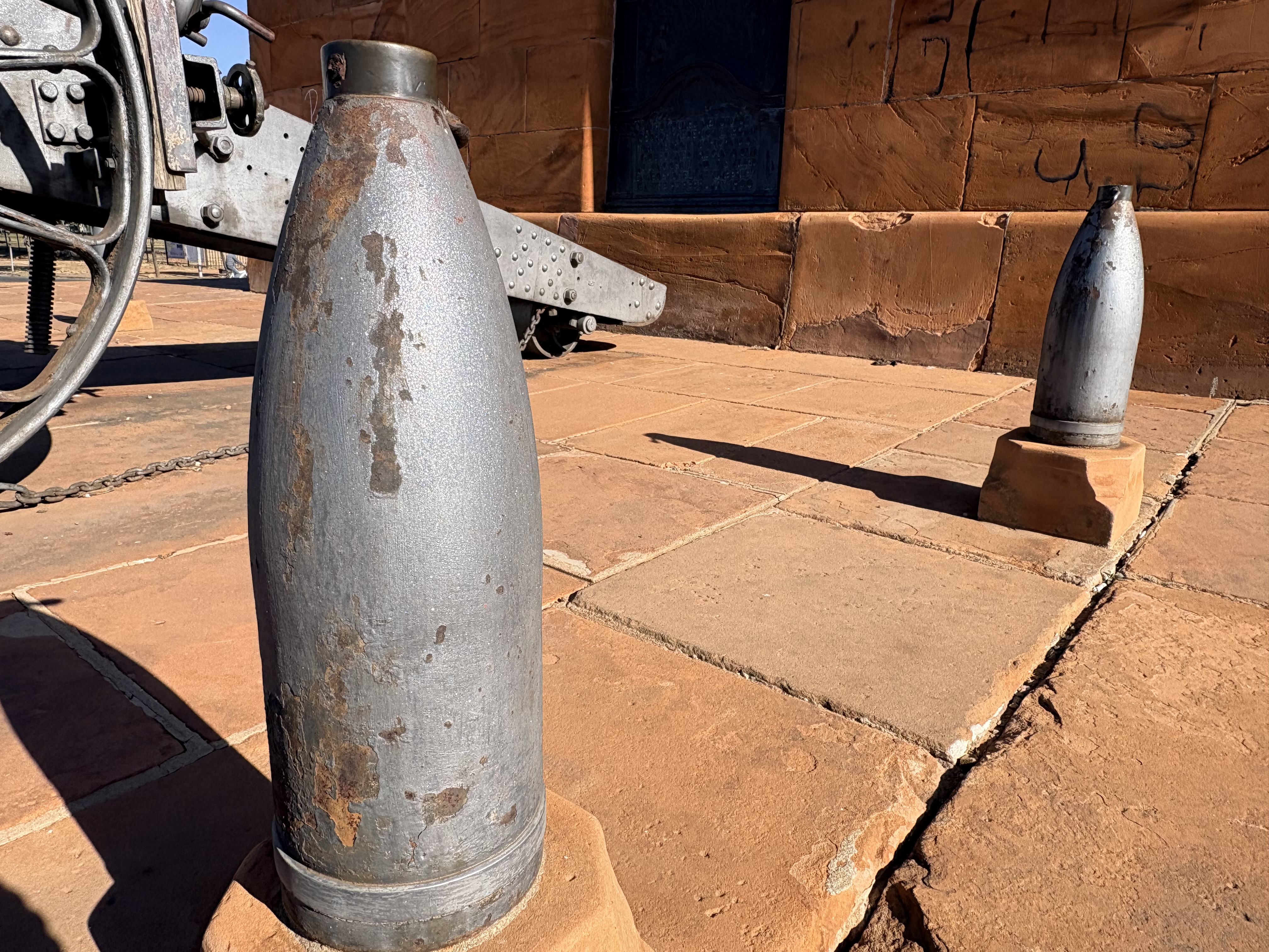 Original Boer Long Tom artillery shells displayed around Long Cecil on the sandstone stylobate of the Honoured Dead Memorial in Kimberley.