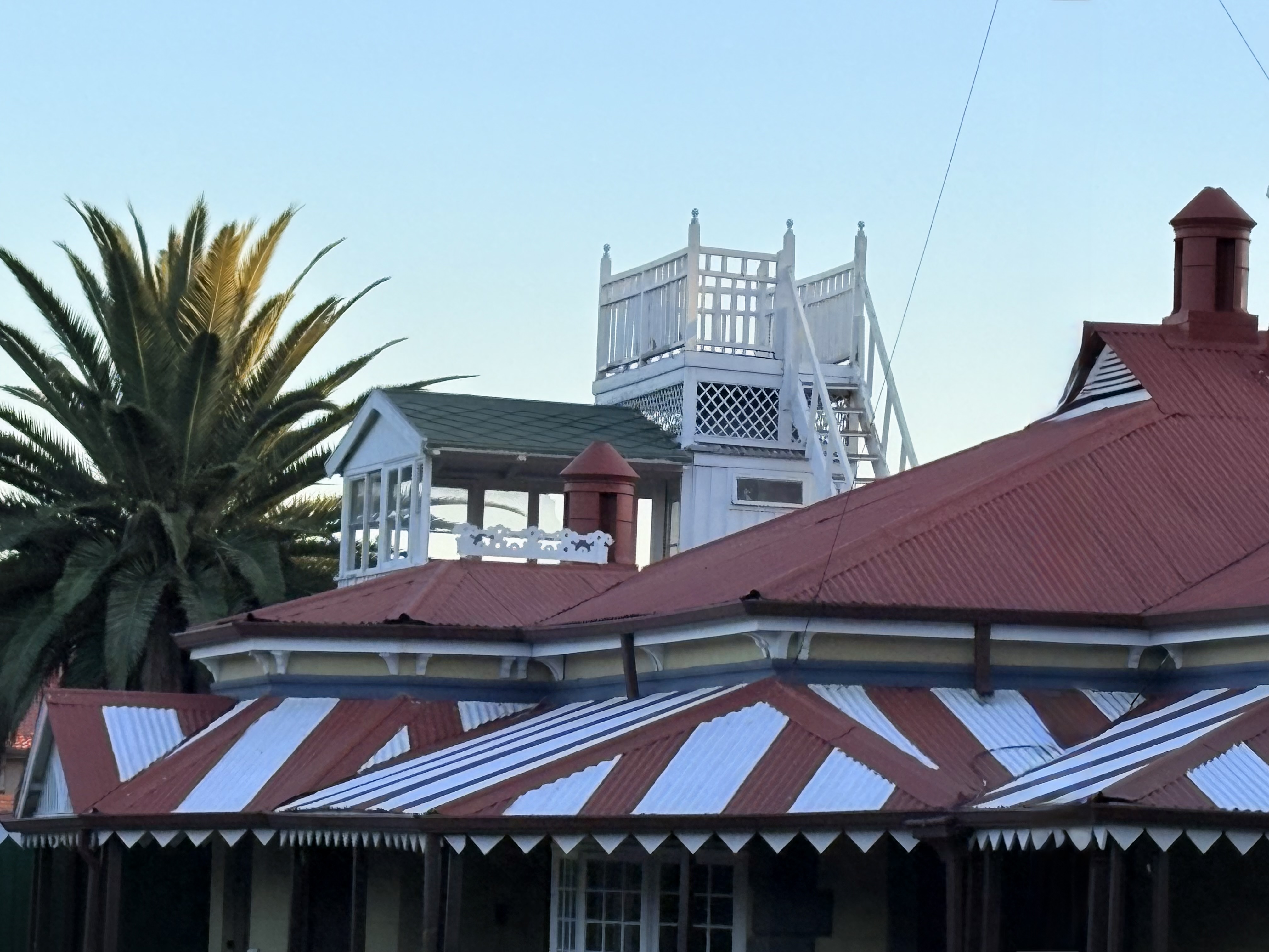 Close-up view of the ornate roofline of Rudd House in Kimberley, highlighting its late Victorian timber gables, lookout tower and intricate architectural detailing.
