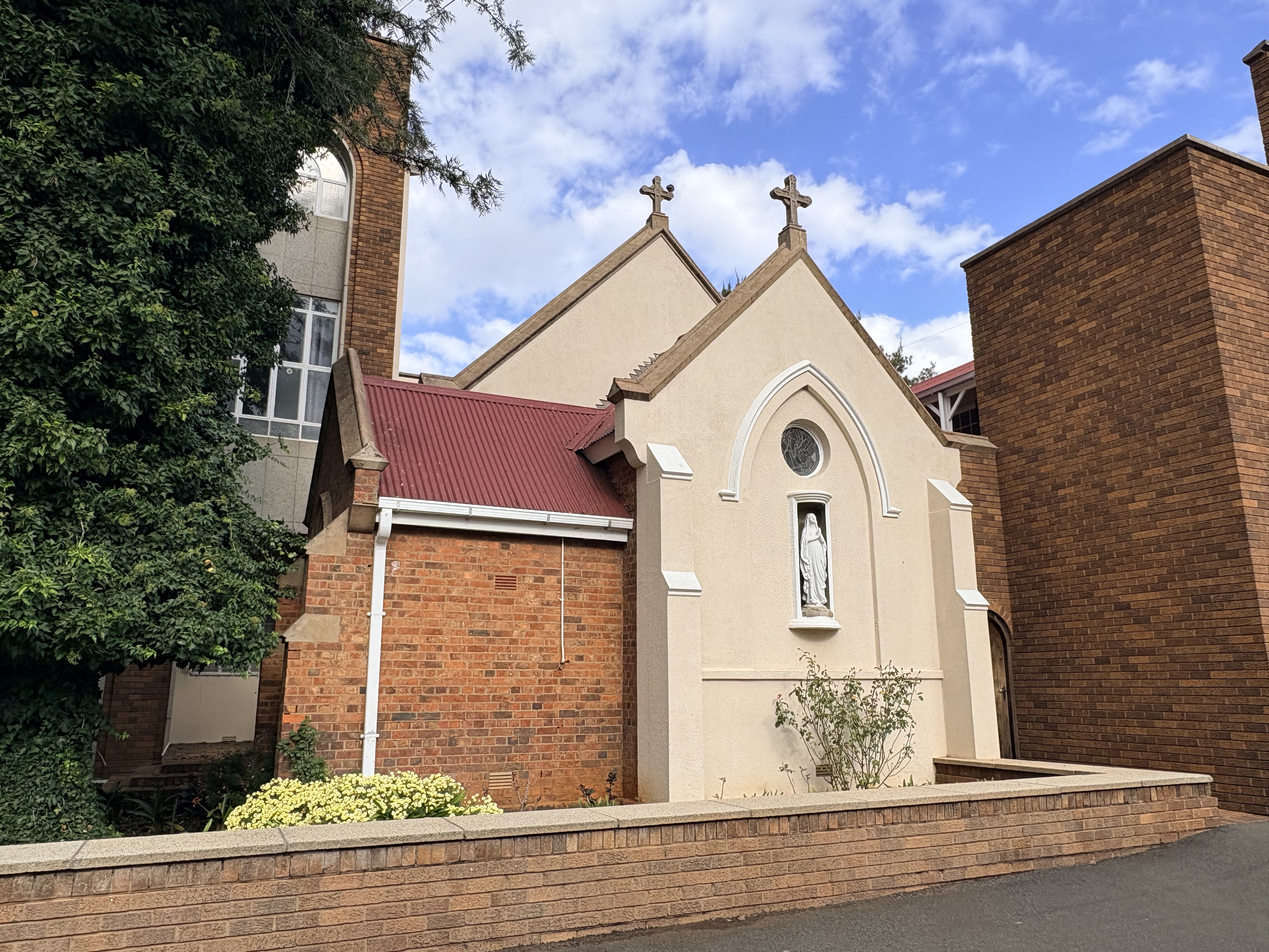 Sanctuary end of the Holy Ghost Chapel at St Patrick's CBC in Kimberley, showing the small historic chapel tightly enclosed between later school buildings.
