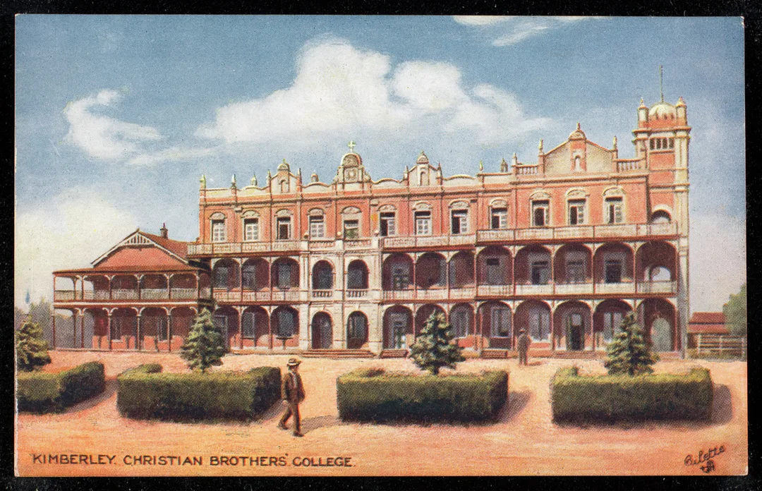 Historic Oilette series postcard showing Christian Brothers’ College Kimberley with red-brick buildings, arcaded verandas, tower, formal gardens and landscaped grounds.
